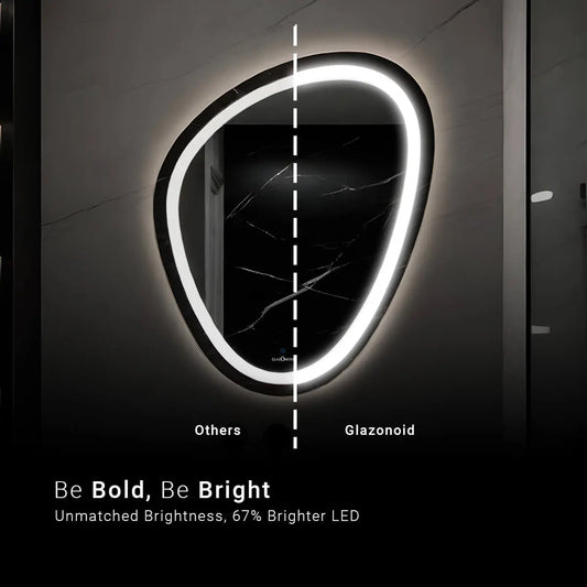 A close-up of a modern bathroom vanity featuring a pebble shaped LED mirror, stating and guiding that the Glazonoid's mirror has better LED light. The mirror is mounted on the wall above a sleek, black countertop with a polished chrome faucet. A white ceramic soap dispenser and two glass jars with chrome lids containing cotton balls and cotton swabs sit on the countertop.