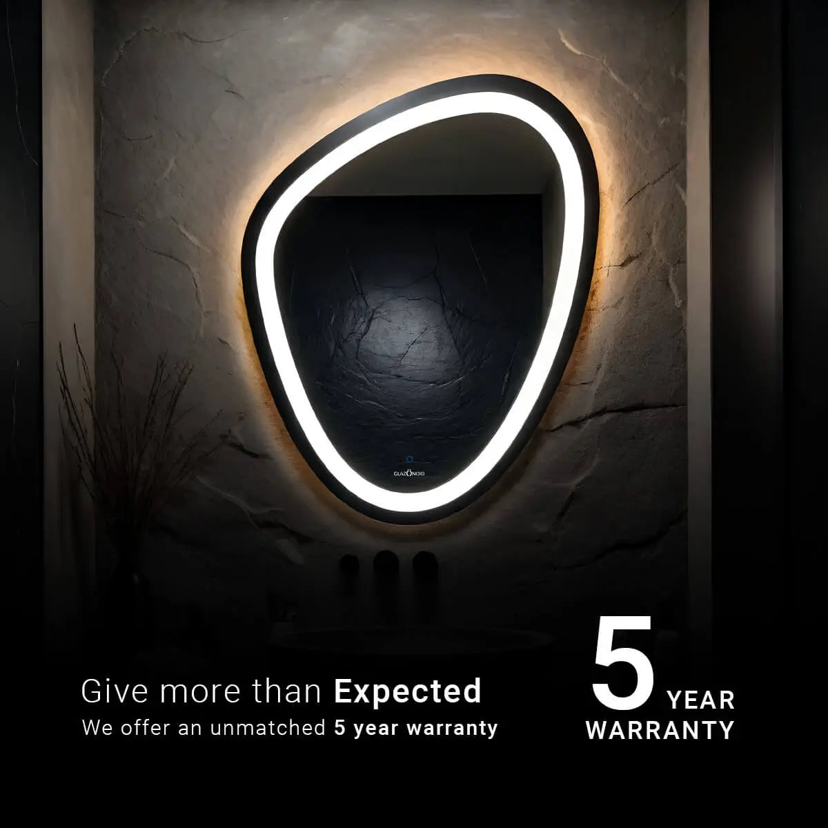 A pebble shaped bathroom mirror with a LED strip light. The text overlay reads 5 year warranty that is being offered by the brand for the products.