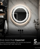 A round mirror is mounted on the wall above a white bathtub. Text overlay on the image reads 