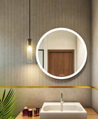 round wall mirror with lights above washbasin