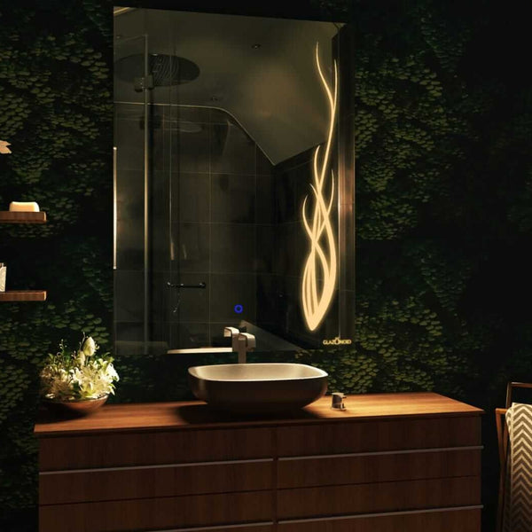 Designer rectangular bathroom mirror with a built-in LED light frame. The mirror is mounted above a white ceramic sink with a chrome faucet. The mirror has a design of a growing plant.