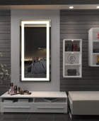 Modern well lit and airy living room with a long rectangular LED mirror with an elegant border design mounted on the wall. Along with a plant and some compartments to store the daily essentials.