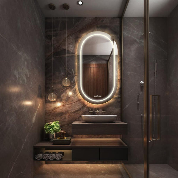 A modern bathroom vanity with a polished chrome faucet, a white ceramic sink, and a capsule LED mirror with a LED light behind it.