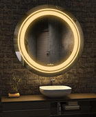 A close-up of a round bathroom mirror with a built-in LED light. The mirror has a frameless design and a two rows of LED lights along edge.washbasin