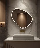 A close up of a modern bathroom vanity with a rectangular sink and a large LED mirror above the sink with a brushed nickel faucet. The mirror contains a touch sensor to control the LED light.